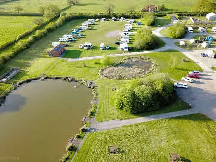 Aerial view of spacious touring caravan pitches and fishing lake at Wagtail Park, York