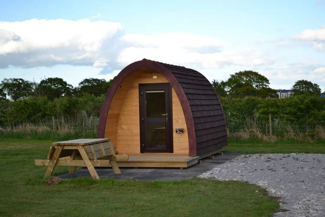 Camping pod with picnic bench and open grass views at Wagtail Park, York