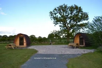 Camping pods on a gravel area with picnic benches at Wagtail Park, York